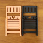 Foldable mini chair mobile phone stand displayed on white background