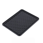 Black anti-skid mat securely holding a phone, keys, and sunglasses on a car dashboard.
