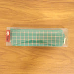 Close-up of high-quality fabric and grid pattern on the green pouch.
