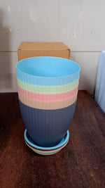 An empty black plastic flower pot with its tray, ready for planting and gardening use.