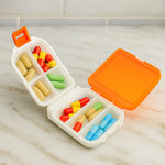 Orange pill organizer box containing vitamins, compact size shown