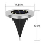 Single solar LED garden light glowing brightly at night in outdoor garden setting
