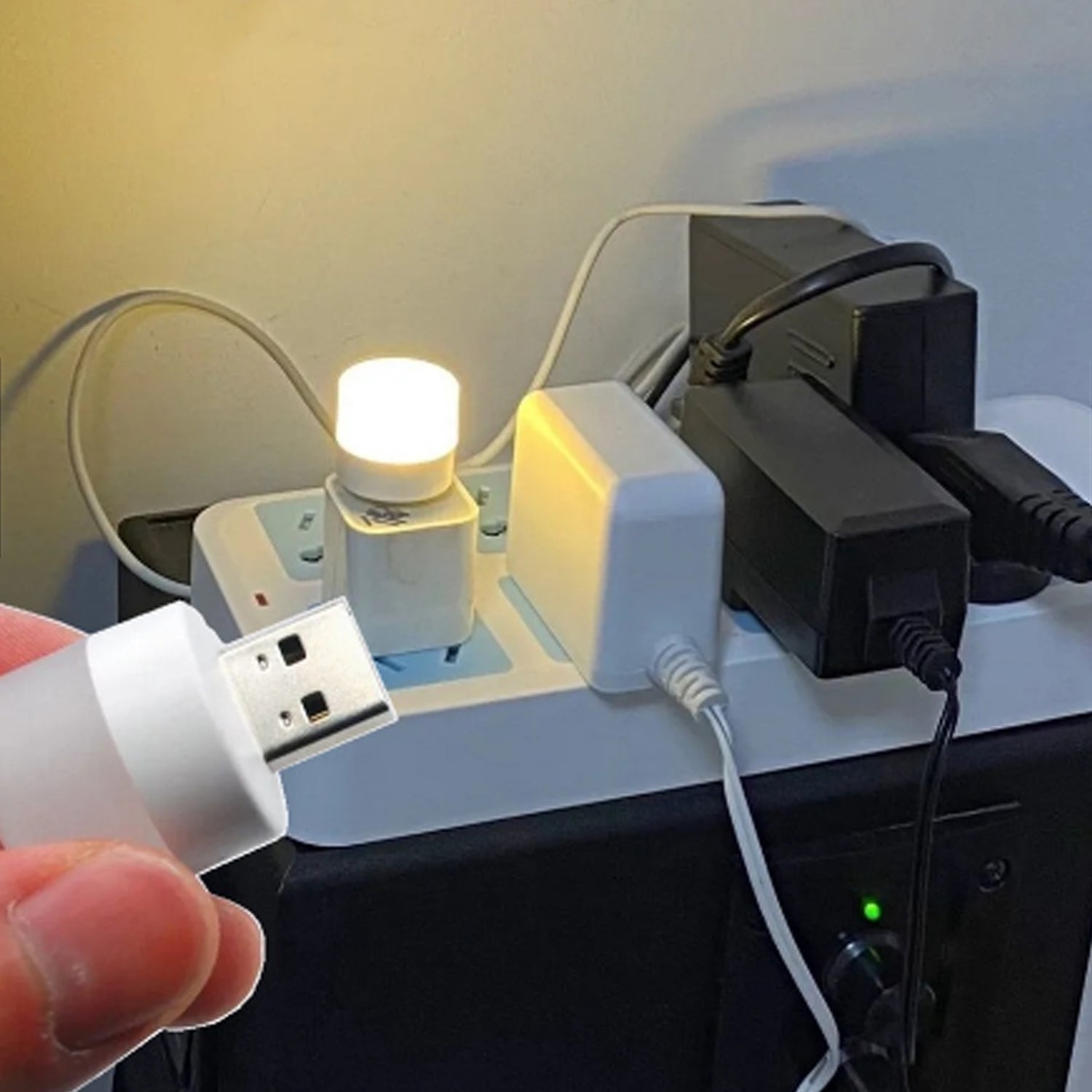 Hand holding the lightweight USB bulb, highlighting its compact size and portability.