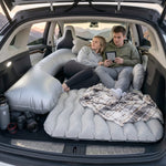 Relaxing couple on car air mattress during road trip