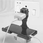 PHOBIA black multi-purpose wall mount stand holding a phone on a wall socket.