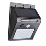 Black solar LED light with motion sensor on a brick wall for outdoor security.