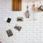 Stainless steel wall hooks neatly holding towels and robes in a bathroom.