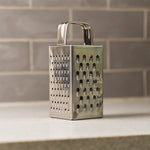 Close-up of multi-sided stainless steel grater and slicer tool