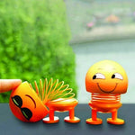 Close-up of a smiling emoticon shaking head doll with a spring neck, perfect for car dashboards.