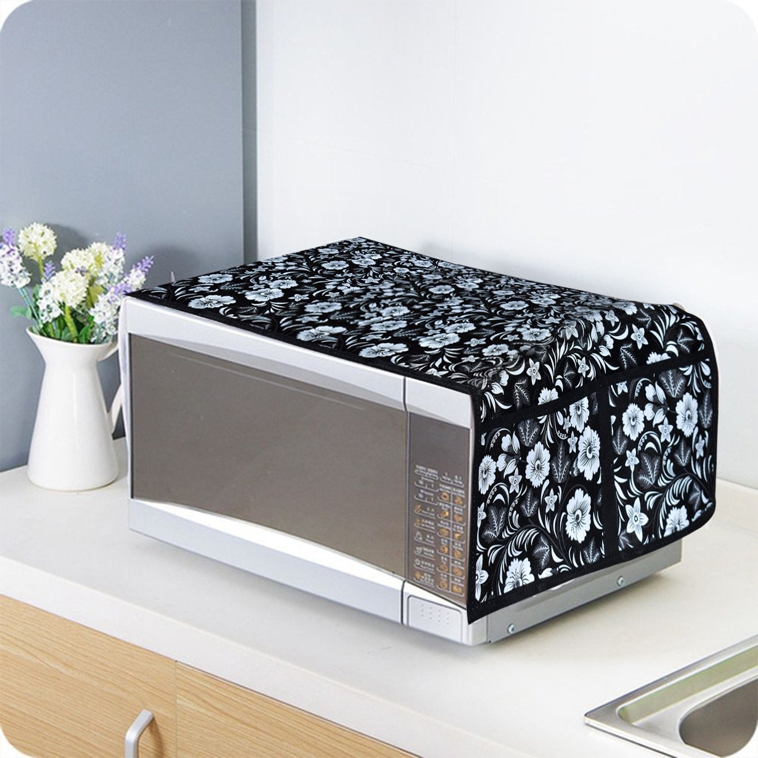 Folded cotton linen microwave cover displayed neatly on a kitchen counter.