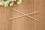 A hand holding a bamboo BBQ skewer with various ingredients for grilling.