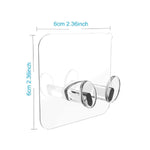 Multi-use transparent wall storage hooks installed in a bathroom, holding bath towels.