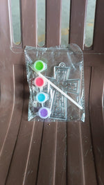 Assorted acrylic paint tubes and a plastic stencil for creative projects.