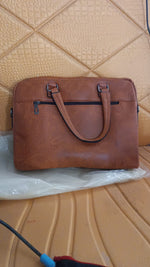 Side view of tan faux leather laptop messenger bag with shoulder strap