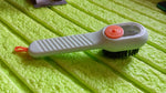 Angled view of the scrubbing brush with dispenser, highlighting its design.