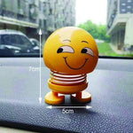 Angled view of an emoticon spring figure with a cheerful smiling face on a white background.