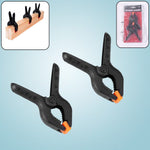 Close-up of a pair of heavy-duty spring clamps for mobile device screen repair.