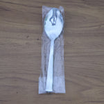 Stacked stainless steel dining spoons placed in a home kitchen setting