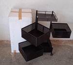 An assembled metal kitchen trolley with wheels, neatly holding various kitchen accessories.