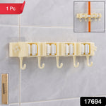 Wall-mounted broom holder securely gripping handles in household utility room