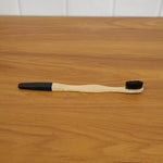 Lifestyle shot of bamboo charcoal toothbrush in use