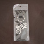 Lifestyle shot of a motorcycle silhouette metal keychain attached to a set of keys.