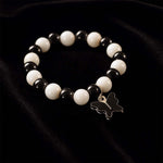 Close-up of black and white beads and cross pendant on bracelet