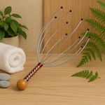 Close-up of the portable handheld scalp massager, showing its smooth resin nubs.