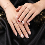 Close-up of glitter 3D floral press-on nails highlighting intricate petal and crystal embellishments.