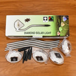 Live image of diamond solar garden lights glowing warmly in an evening garden setting