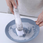 The soap-dispensing dish brush displayed neatly on a kitchen countertop