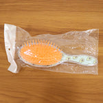 Overhead view of the Soft Cushion Hair Brush, showing flexible bristles and cushioned base.