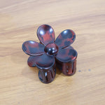 Side profile view showing flower-shaped plastic hair clip clasp