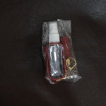 Person holding faux leather hand sanitizer holder keychain with tassel