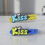 Close-up of cartoon letter Kiss hair pins in a 2-piece set