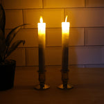 Pair of battery operated flameless LED taper candles glowing warmly during festival celebration