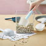 A large plastic measuring spoon shown scooping flour from a bag.