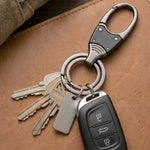 Hand holding compact metal key holder with rotating swivel
