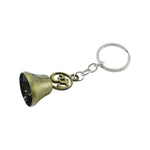 Antique brass Om temple bell keychain displayed on textured surface