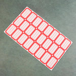 Close-up photograph of red and white self-adhesive rectangular label stickers