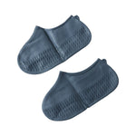 Silicone shoe cover with visible anti-skid sole pattern on a wet, tiled surface.