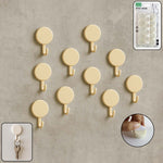 Set of 10 self adhesive round wall hooks arranged neatly for home organization