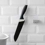 A sleek black punch-free wall hanging knife holder mounted on a kitchen wall, showcasing its modern design and space-saving functionality.