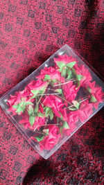 Packaging of the 12-piece red rose hair clip set, ideal for gifting.