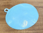 Kitchen setting featuring blue silicone dish scrubber for cleaning