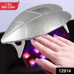 Hand with gel nails curing under the portable Mini UV LED nail lamp at home.