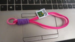 Securely attached multi-color wrist strap lanyard on a smartphone, preventing drops.