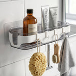 Transparent bathroom shelf holding toiletries and small items