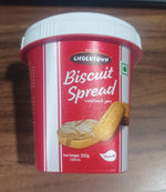 A spoon dipped into a jar of Chocotown Caramelised Biscuit Spread, demonstrating its smooth consistency.