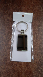 Angled view of rectangular metal keychain with black and silver finish